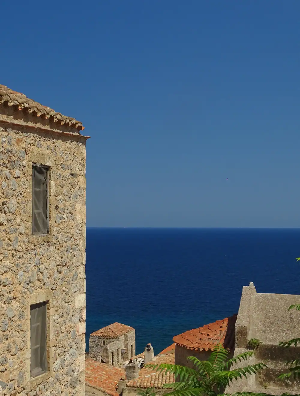 Maisons de pierre au-dessus d'une mer d'un bleu profond